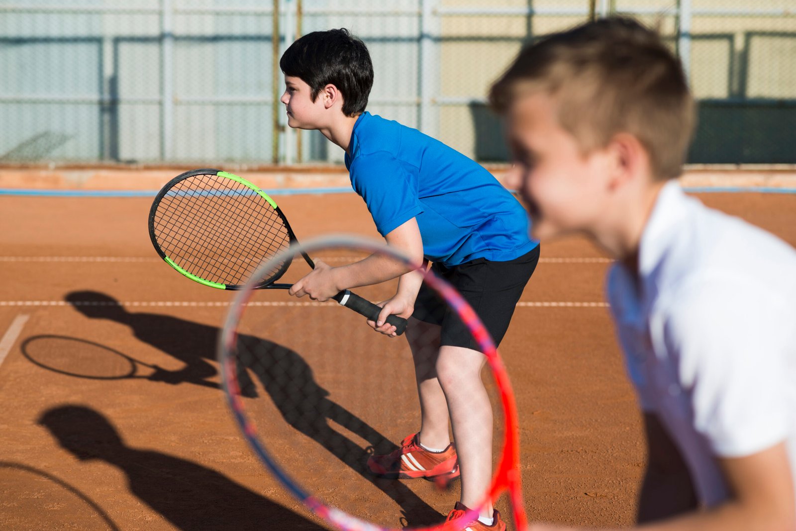 sideways-kids-playing-doubles-tennis